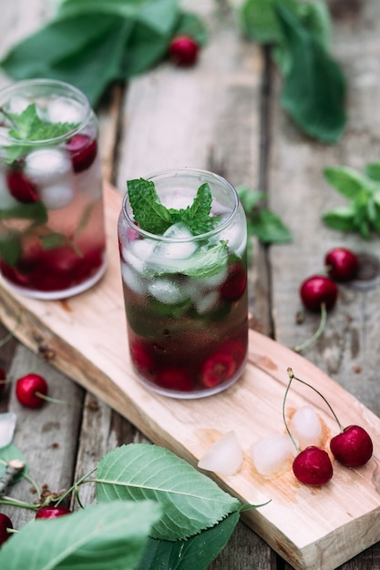 Cherry cocktail with ice and mint in a glass