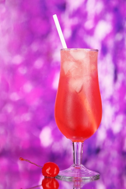 Cherry cocktail with ice on purple background