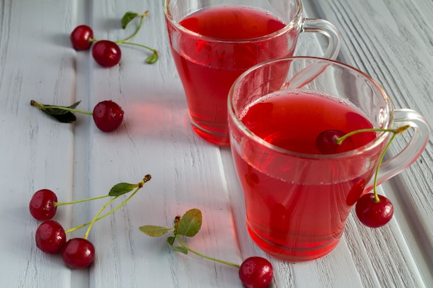 Cherry compote in glass cups on the grey wooden table