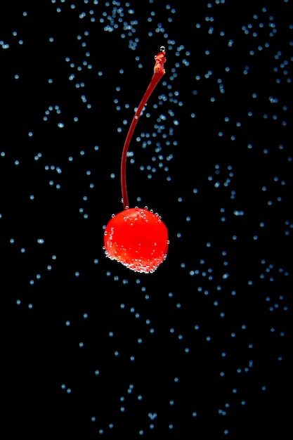 Photo cherry covered with bubbles isolated on black