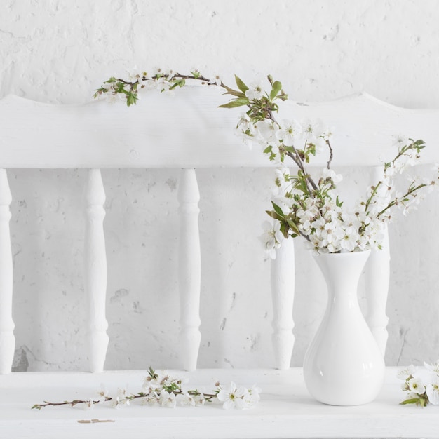 Cherry flowers in vase on white background