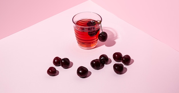 Cherry juice with pink background high angle