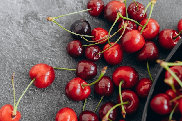 Cherry pattern Flat lay of cherries and leaves on a dark backgroundTop view