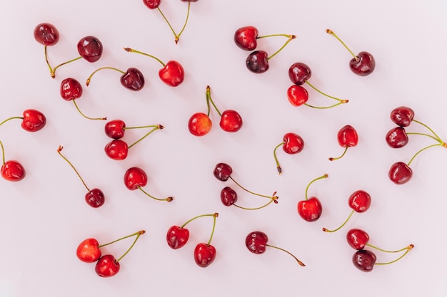 Cherry pattern Flat lay of cherries on a pink backgroundTop view