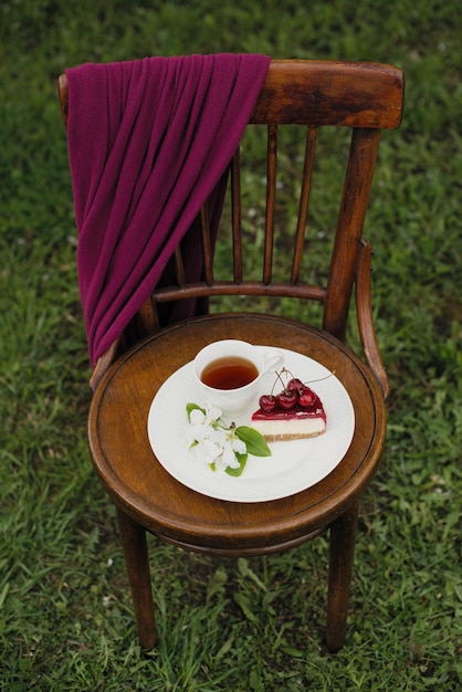 Cherry pie decorated in the garden on a wooden chair