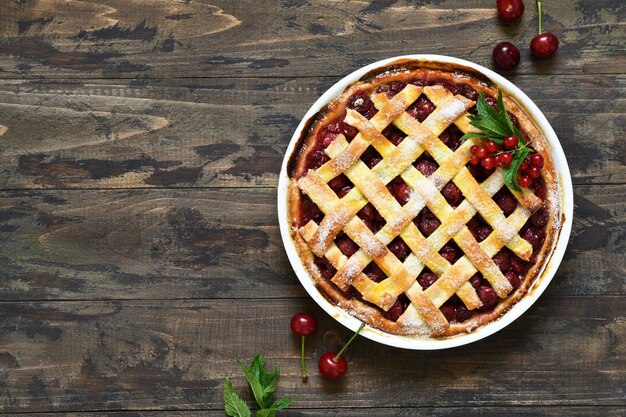 Cherry pie on a wooden background with place for text. View from above.