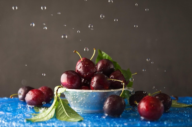 Cherry on platter on blue background with drops