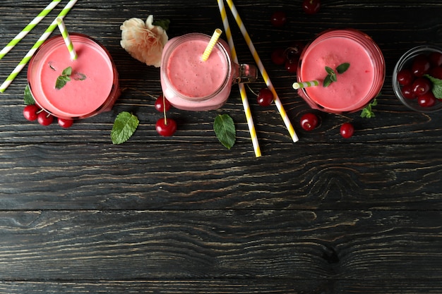 Cherry smoothie and ingredients on rustic wooden table