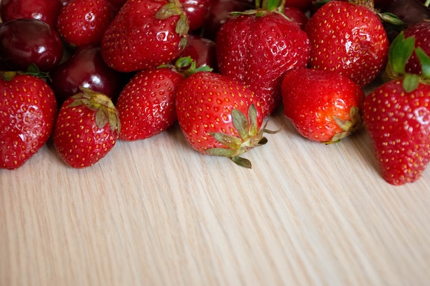 Cherry and strawberry on a white wood 