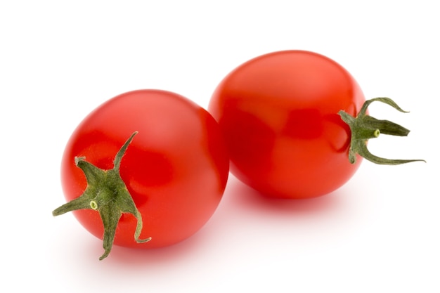 Cherry-tomaten. Drie kerstomaatjes op een wit oppervlak.