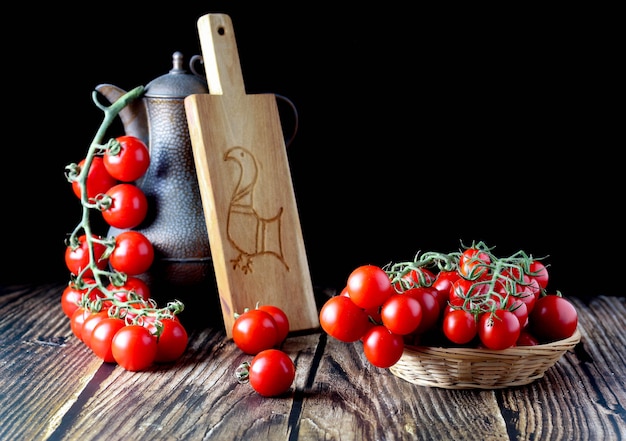 Cherry tomaten in mand, met vintage kruik en Sardijnse artistieke snijplank