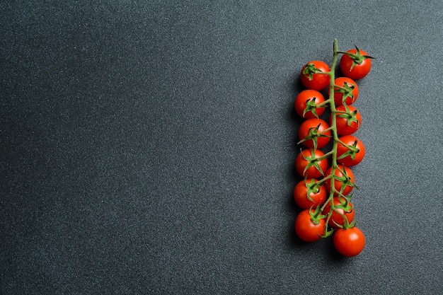 Cherry tomaten op een takje op een zwarte achtergrond bovenaanzicht Vrije ruimte voor tekst