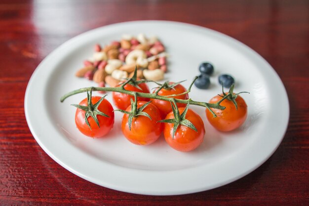 Cherry Tomaten op witte kom met noten - voedsel achtergrond, close-up