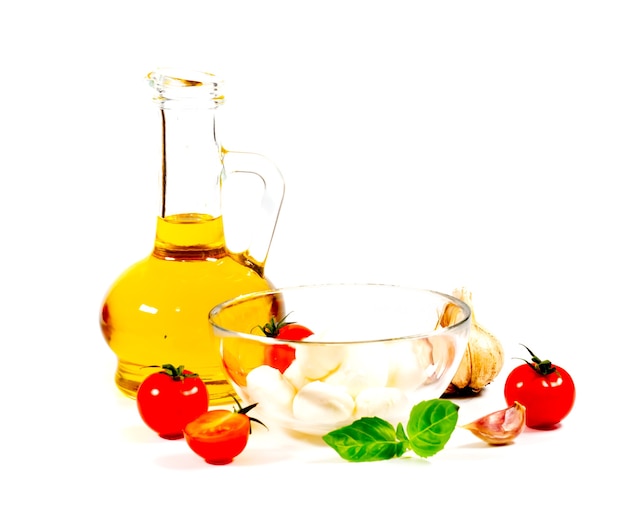 cherry tomatoes and basil in glass bowl on white background