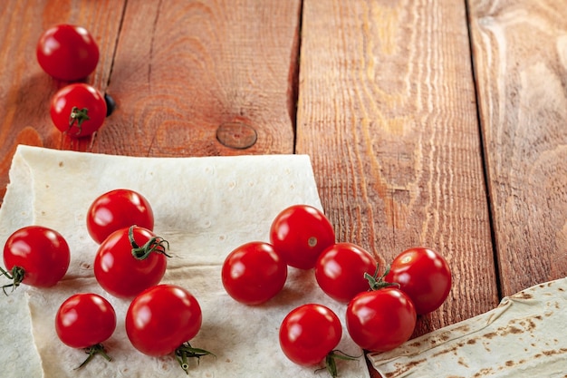 Cherry tomatoes and bread on wooden background