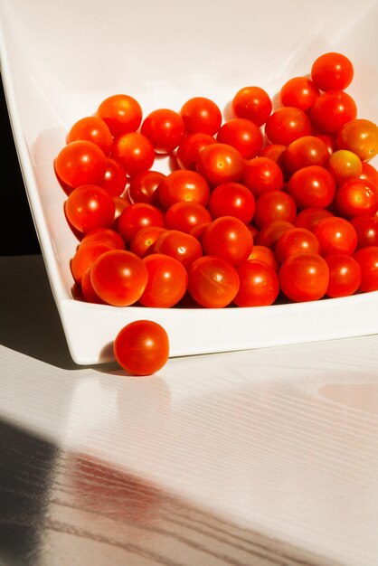 Cherry tomatoes. Cherry tomatoes in a white plate. Hard light. Bright light and shadow.