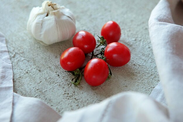 Cherry Tomatoes and Garlic on concrete surface with linen Vegetables for pizza