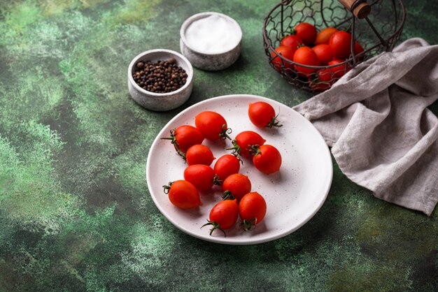 Cherry tomatoes on green background