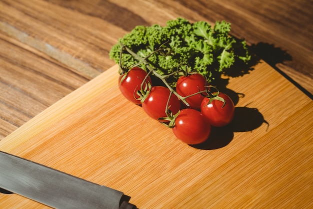 Cherry tomatoes and parsley on chopping board