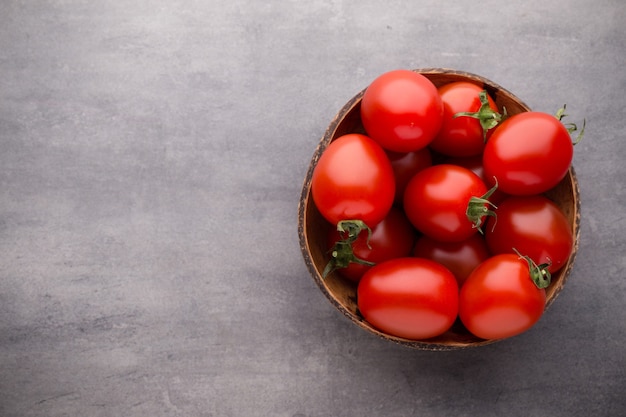 Cherry tomatoes. Three cherry tomatoes in a wooden bowl