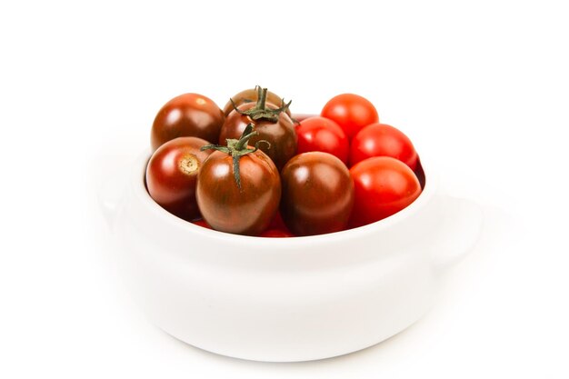 Cherry tomatoes in a white bowl on a white background