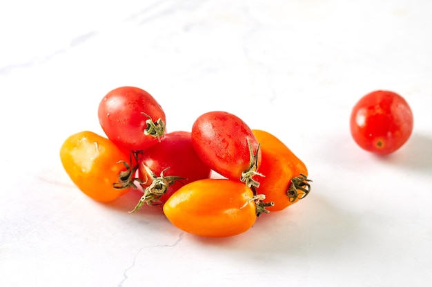 Cherry tomatoes on white marble ready to cook and eat