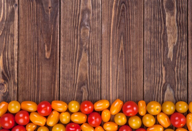 Cherry tomatoes on wooden table , top view