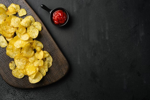 Chesapeake Bay Crab Spice Flavored Potato Chips on black dark stone table background top view flat lay with copy space for text