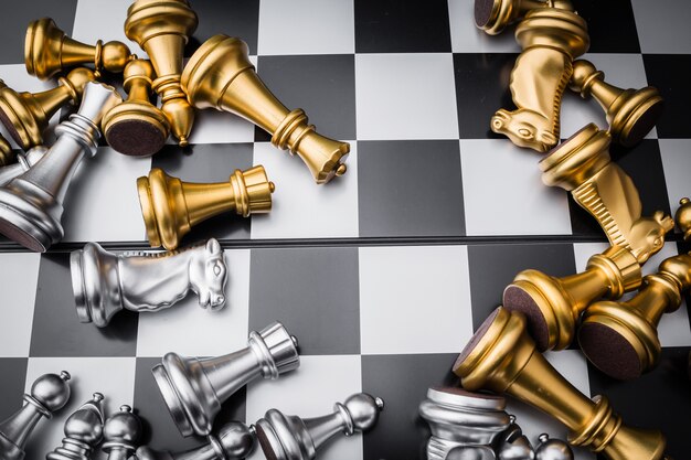 Premium Photo  The silver horse, knight chess piece standing with falling  golden queen, rook, bishop, pawn pieces on chessboard on dark, vertical.  leadership, winner, competition, and business strategy concept.