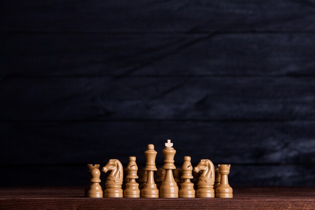 暗い背景の上のチェスの駒とチェス盤