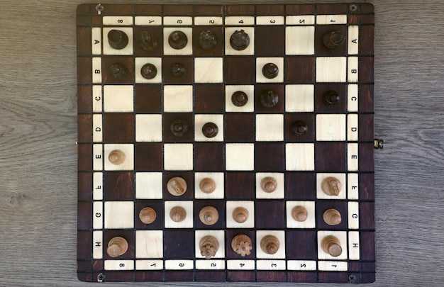 The chess board with the pieces in the dark vintage room