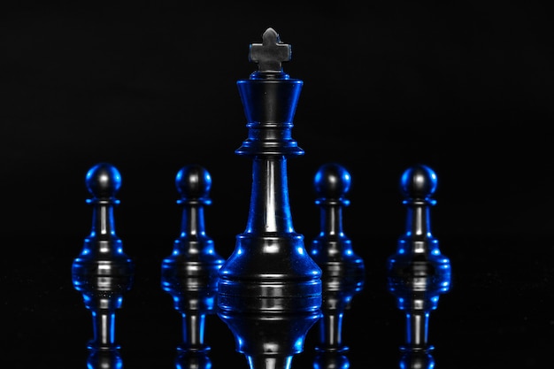 Chess figures on black background with blue backlight