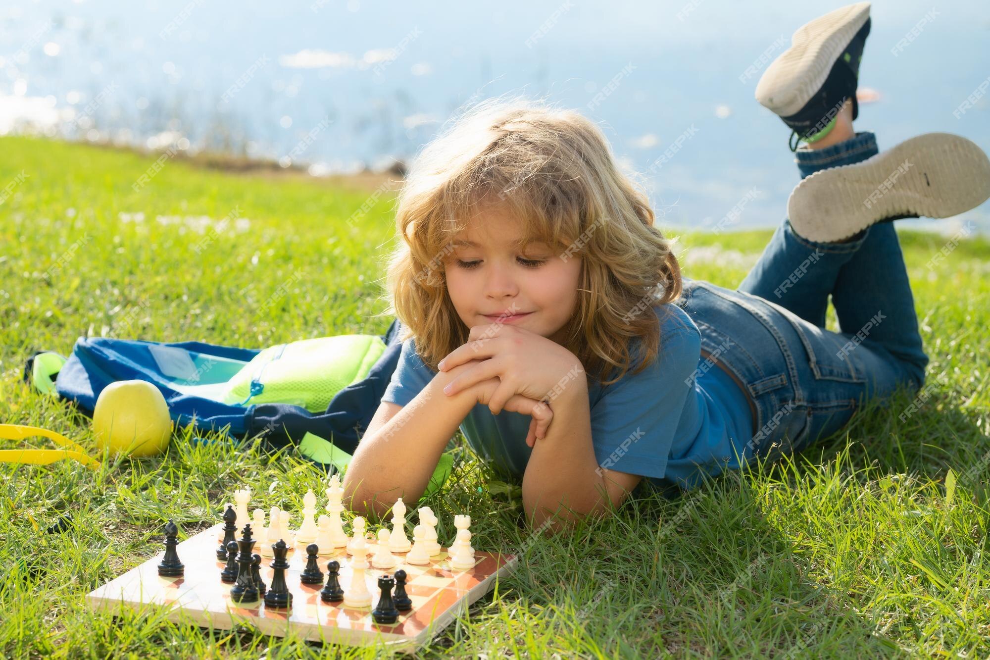 Kid Boy With Glasses Playing Online Chess Board Game On Computer