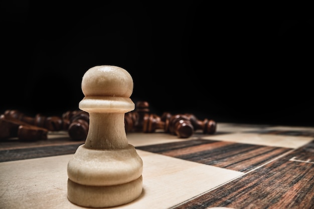 Chess game with chess pieces against black background close up