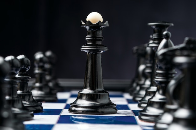 Chess king among his black pieces