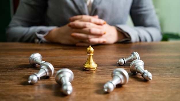 Photo chess leadership victory concept with gold winner stand alone with fallen silver chess pieces king wins the game decision and achievement goal concept with chess figures
