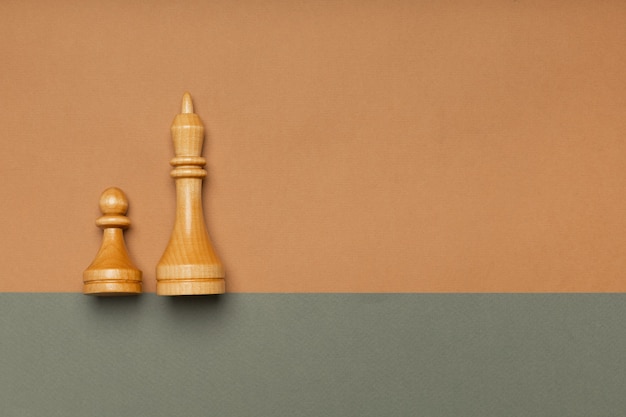 Chess pawn and king on flat background top view