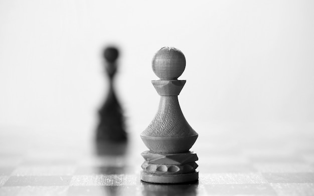 Шахматная фигура пешка на доске на белом фоне