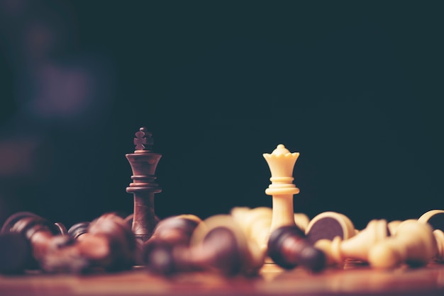 Chess pieces on the board. Black wood background behind.