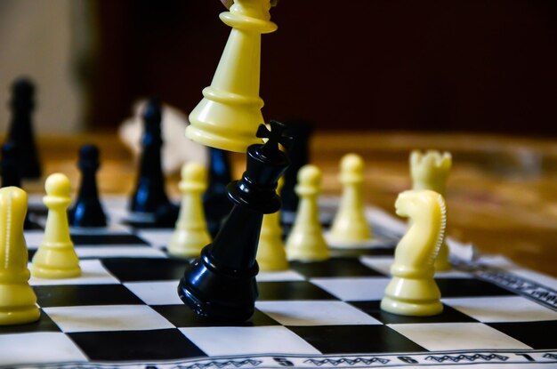 Chess pieces on the chess board. Chess playing at home. Checkmate by the queen