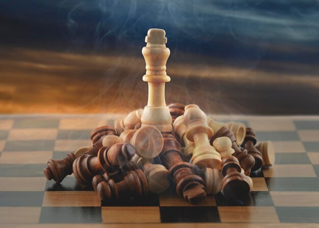 chess pieces on chessboard are stacked and the king is at top against dramatic sky Win at any cost