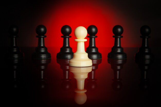 Photo chess pieces on dark background with red backlight close up