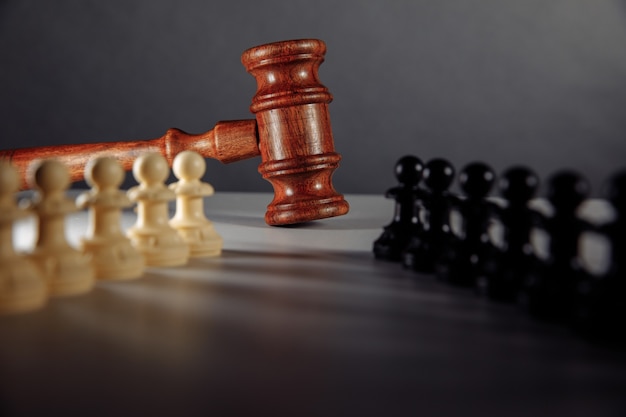 Chess pieces and law gavel on a table