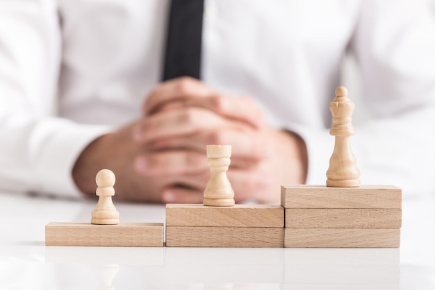 Chess pieces on stacked stepped wooden blocks