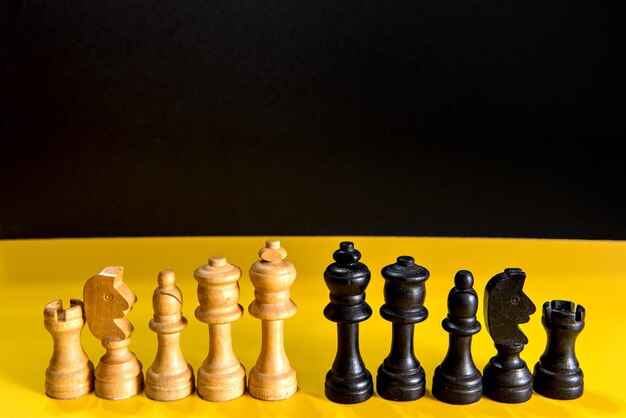 Chess pieces on yellow and black background game of chess