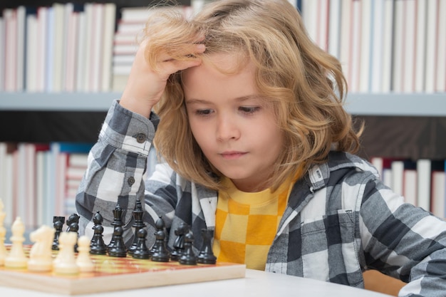 Шахматная школа, маленький ребенок, играющий в шахматы, думающий, детская шахматная игра для детей, умный, умный и умный