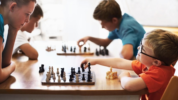 Chess whiz Young boy wearing spectacles and playing chess with an older child