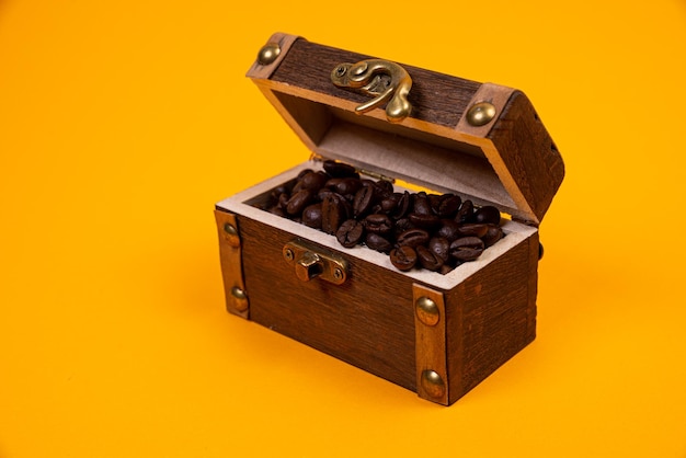 Сундук с кофе Изображение немолодых кофейных зерен Пересыпано в пиратский сундук Драгоценный дорогой тоник бодрящий ароматный вкусный качественно обжаренный напиток Коричневый