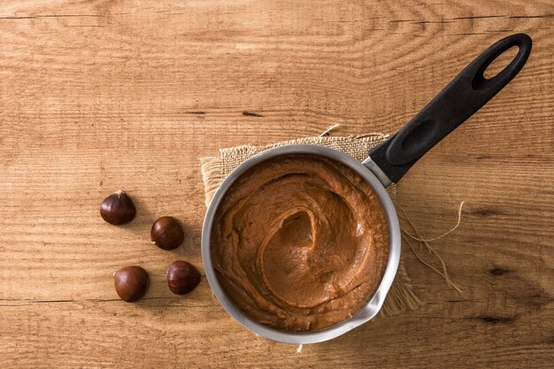 Chestnut cream on pot wooden table Top view