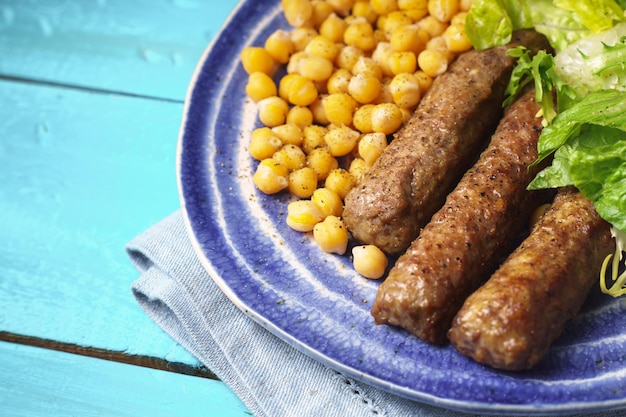 Chevanchichi with lettuce and chickpea on a blue plate